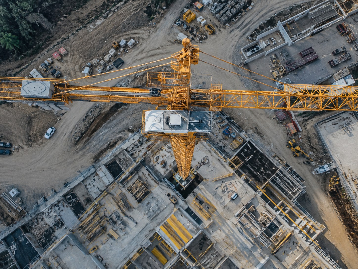 Aerial view of a Beni Dona construction site, tower crane over the building's rising floor plates