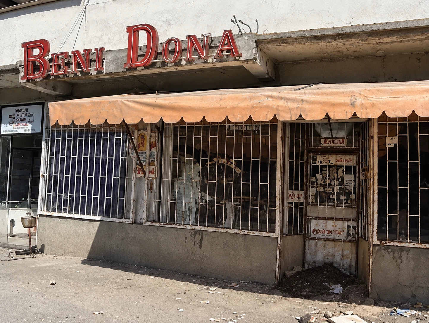 The original Beni Dona storefront, its weathered red lettering and barred windows behind a faded awning
