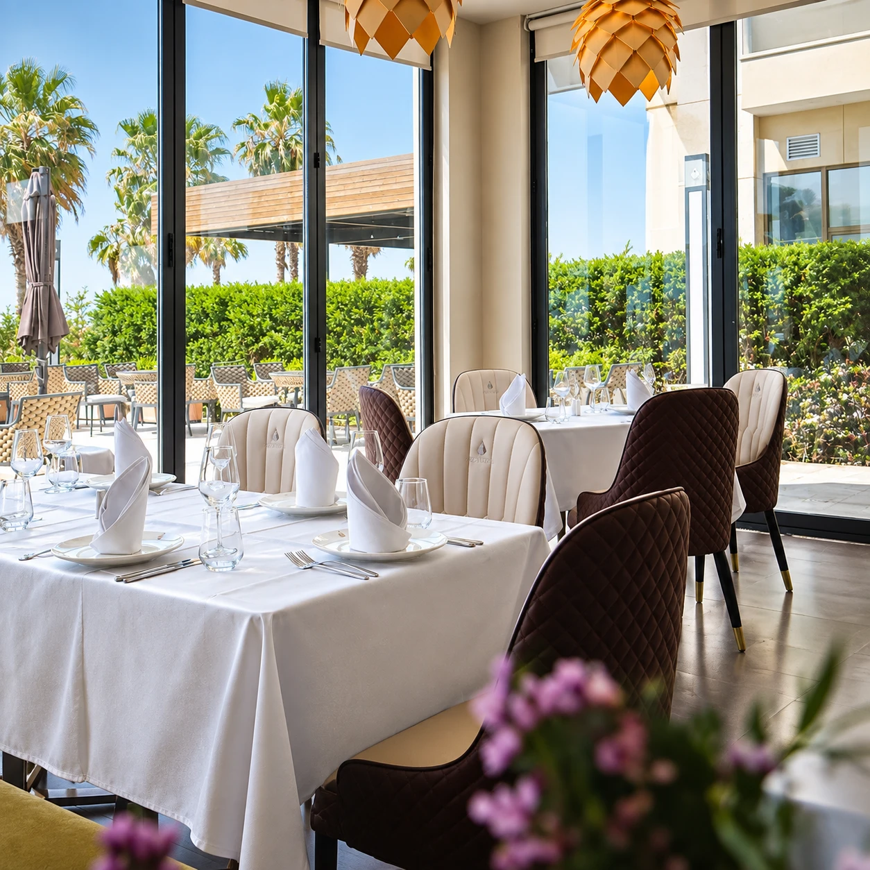 Hotel Pinea's restaurant dining room, white-clothed tables and upholstered chairs