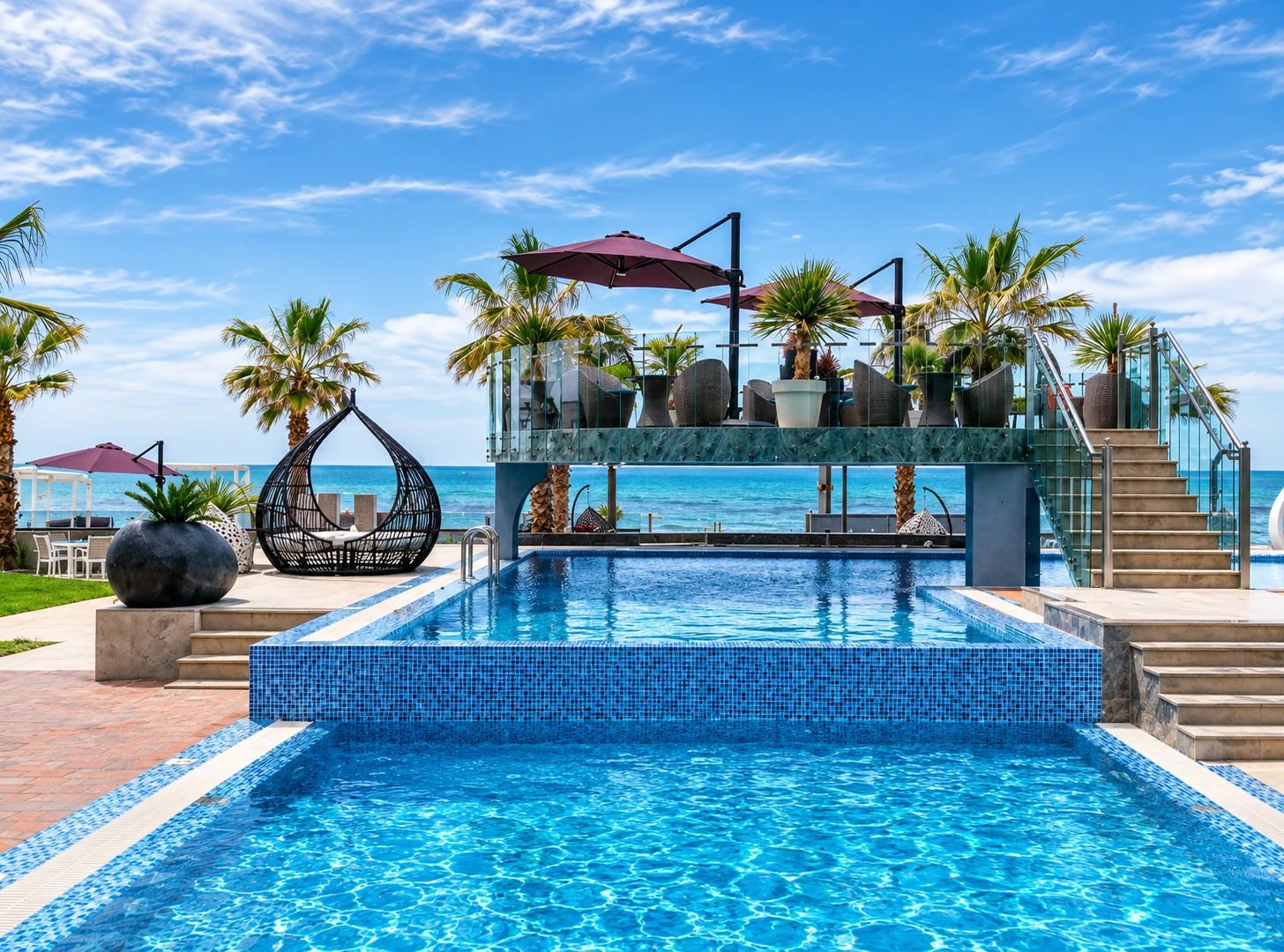 Hotel Pinea's pool deck, sun umbrellas and palm trees with a sea view