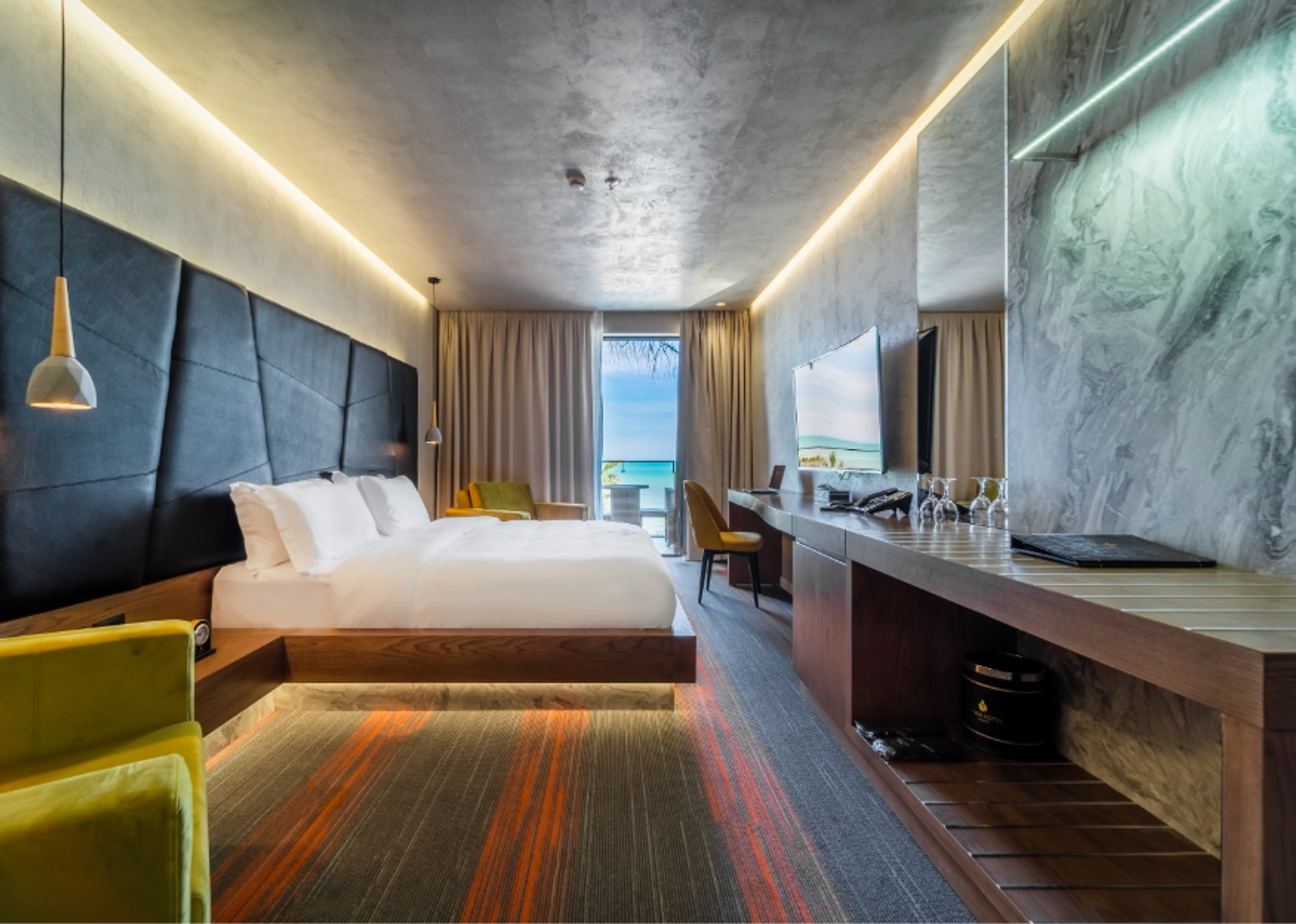 A Hotel Pinea Grand Deluxe room, a long marble desk and a terrace with a sea view